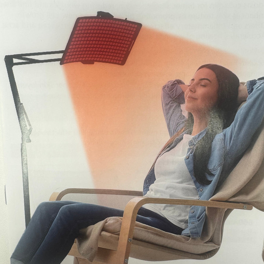 Person sitting in a chair with a light therapy lamp above them